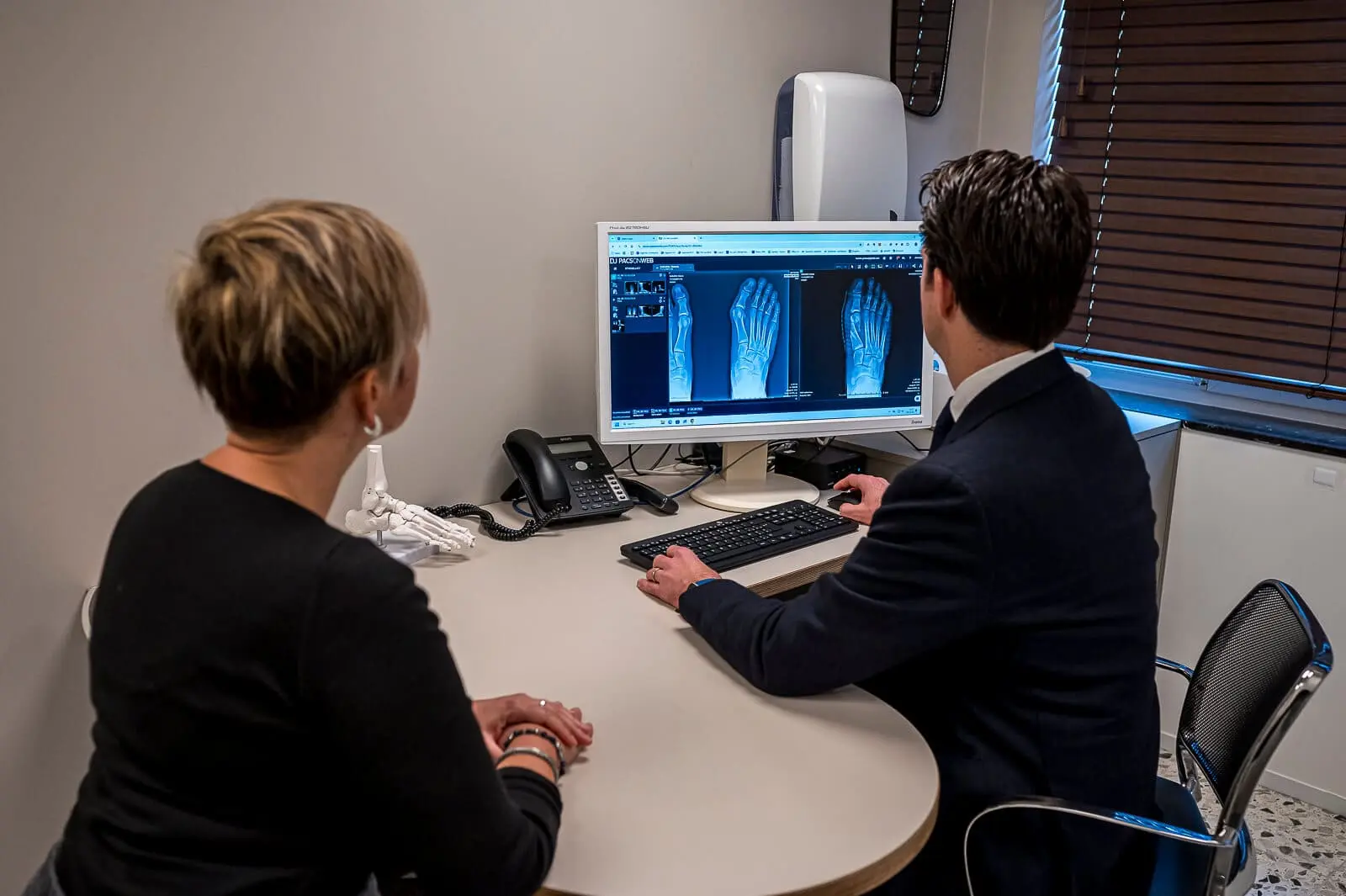 Orthopedisch chirurg die röntgenfoto's van de voet analyseert – informatie over zorg en publicaties